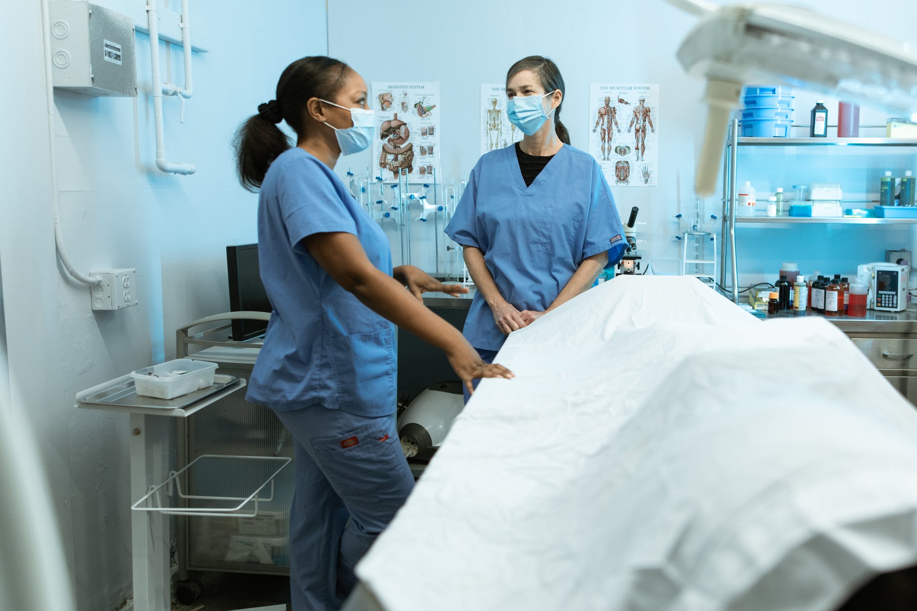 two female nurses talking with facemasks on